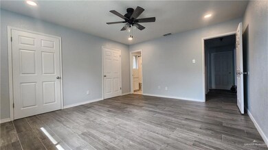 Unfurnished bedroom featuring wood finished floors, baseboards, recessed lighting, ensuite bathroom, and ceiling fan