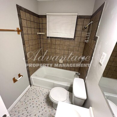 Bathroom with tile patterned floors, toilet, and t