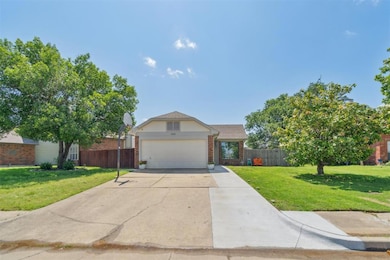 Traditional-style home with brick siding, an attached garage, and driveway