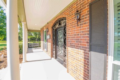 Wrap around porch and view of front wrought iron arched doorway.