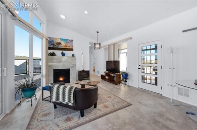 Living room featuring vaulted ceiling, cozy firepl