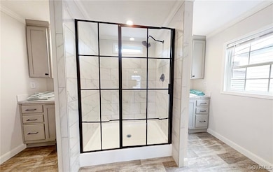 Bathroom with crown molding, vanity, a stall showe
