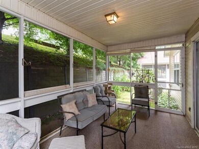 The shaded screen porch backs up to retaining wall for privacy with exterior door.