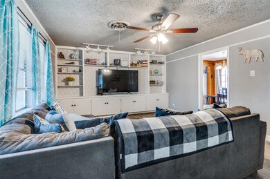 Living room featuring visible vents, a textured ce