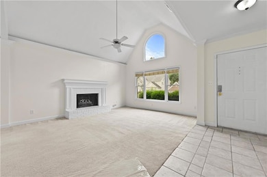 Unfurnished living room with ceiling fan, high vau