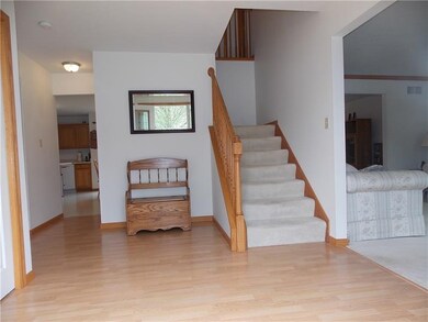 Open entry with laminate flooring, leads to dining