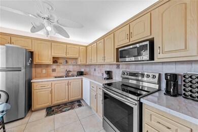 Kitchen with tasteful backsplash, light tile patte