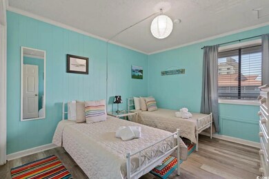 Bedroom with ornamental molding, baseboards, and wood finished floors