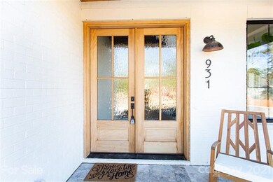 Check out this walnut stained door with gorgeous glass privacy panels as it blends beautifully with both the outside all this white all brick home with the complimentary silver travertine front walkway.