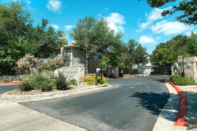 View of asphalt street with a gate, curbs, and a 