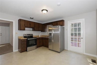 Kitchen featuring appliances with stainless steel finishes, dark brown cabinets, and light countertops