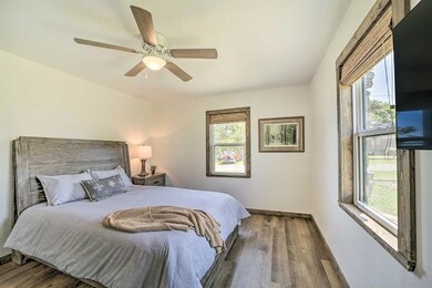 Bedroom with wood finished floors, a ceiling fan, 