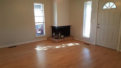 Living area with cozy corner fireplace, wood lamin