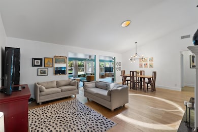 Living room featuring vaulted ceiling, light wood