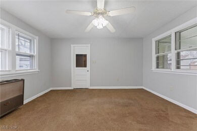 Carpeted empty room featuring ceiling fan and baseboards