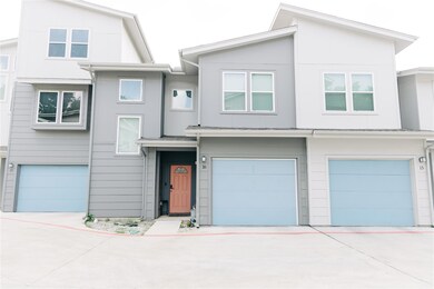 View of front of home featuring a garage and driv