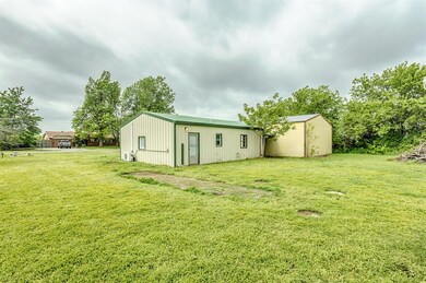 Back of property with a lawn and an outbuilding