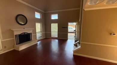 Unfurnished living room featuring a brick fireplace, a high ceiling, dark wood-style floors, and crown molding