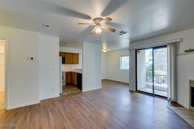 Unfurnished living room featuring dark wood-style floors, a ceiling fan, and a textured ceiling
