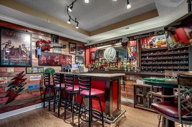 Indoor dry bar featuring a textured ceiling, wood finished floors, and track lighting
