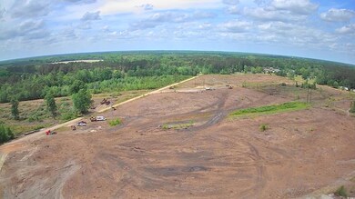 Aerial view of property's location featuring a heavily wooded area and rural landscape