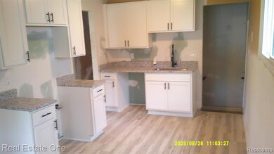 Kitchen featuring white cabinetry and light wood-type flooring