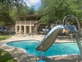 Swimming pool with a water slide and a patio