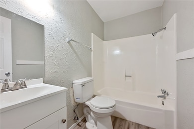 * Hall bathroom with shower / tub combination, quartz vanity, and wood finished floors
