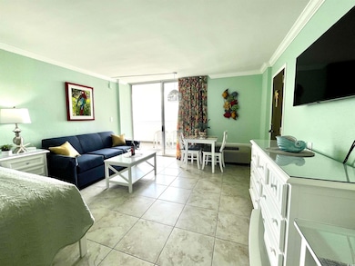 Living area with floor to ceiling windows, ornamental molding, and light tile patterned floors