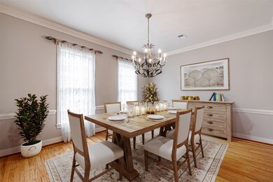 Dining room features hardwood flooring, crown mold
