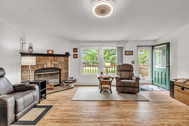 Living room with wood finished floors and a stone 