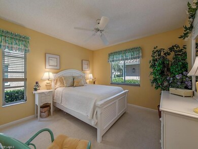 Bedroom with light colored carpet, baseboards, and ceiling fan