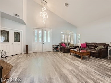 Living area with high vaulted ceiling, light wood