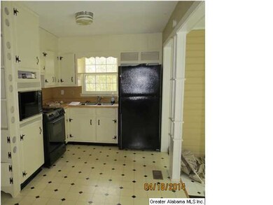 Open kitchen with black appliances, gas cooktop