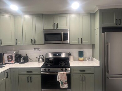 Kitchen with appliances with stainless steel finishes, backsplash, and light stone counters
