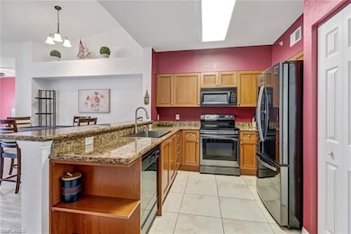 Kitchen with open shelves, black appliances, a kitchen breakfast bar, dark stone counters, and a peninsula