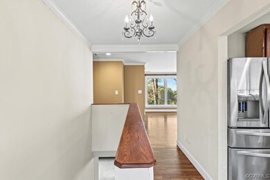 Hall featuring a chandelier, crown molding, and da