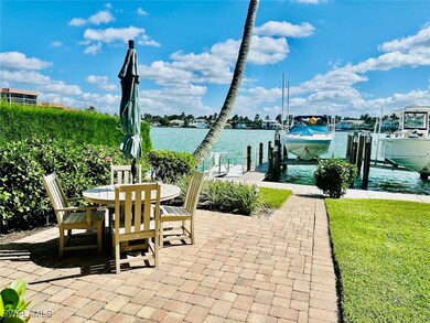 View of patio with a water view, boat lift, a dock, and outdoor dining space