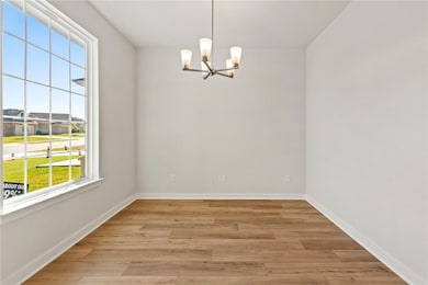 Unfurnished room featuring light wood-type flooring and a chandelier