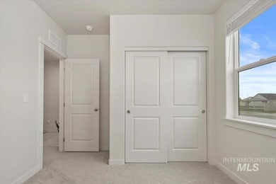 Unfurnished bedroom with light colored carpet and a closet