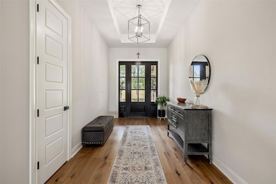 Entryway with a chandelier, light wood-style floo