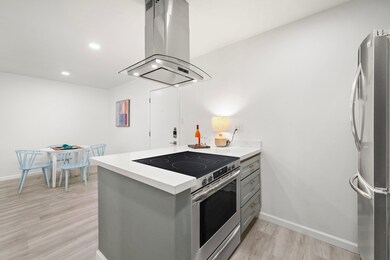 The kitchen is accented with neutral tones, white
