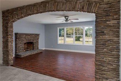 Stunning stone archway lead to Living Room with matching Stone Fireplace!