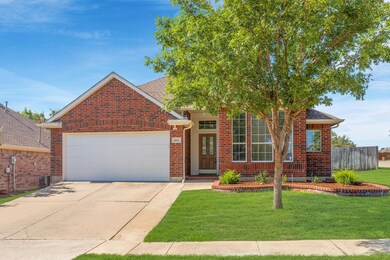 View of front facade featuring a garage and a front lawn