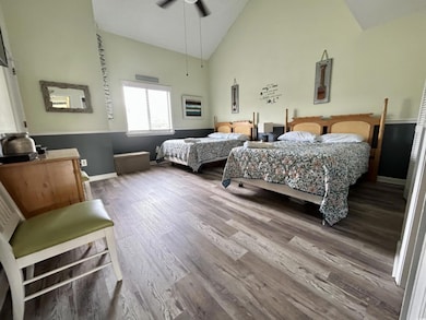 Bedroom with hardwood / wood-style floors, high va