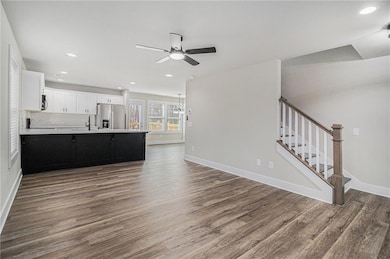 Kitchen with backsplash, white cabinets, ceiling f