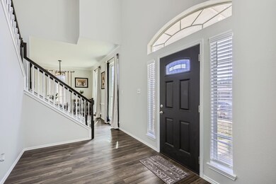 Entrance foyer featuring a chandelier and dark har