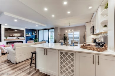 Kitchen featuring open floor plan, a peninsula, white cabinets, a kitchen breakfast bar, and open shelves