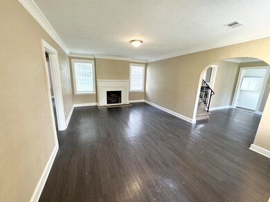Unfurnished living room with crown molding, dark h