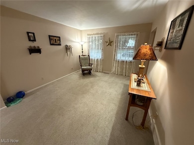 Sitting room featuring carpet flooring and baseboards